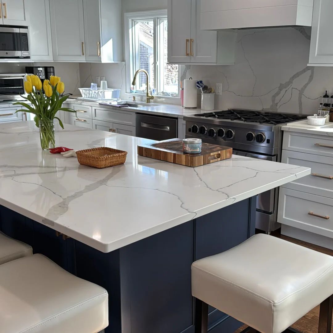 The same Cape Cod kitchen after the house cleaning, with a clear, polished marble island